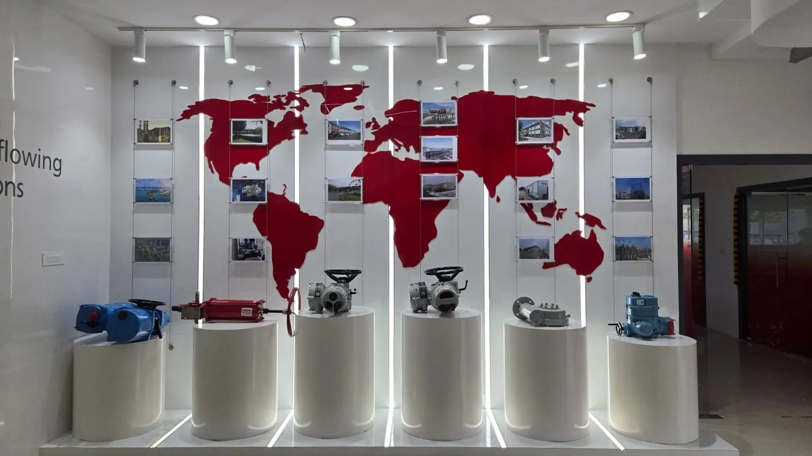 World Map Graphic with Suspended Photo Frames and Circular Pedestal Displays Glass Partitions Desk and Decor 