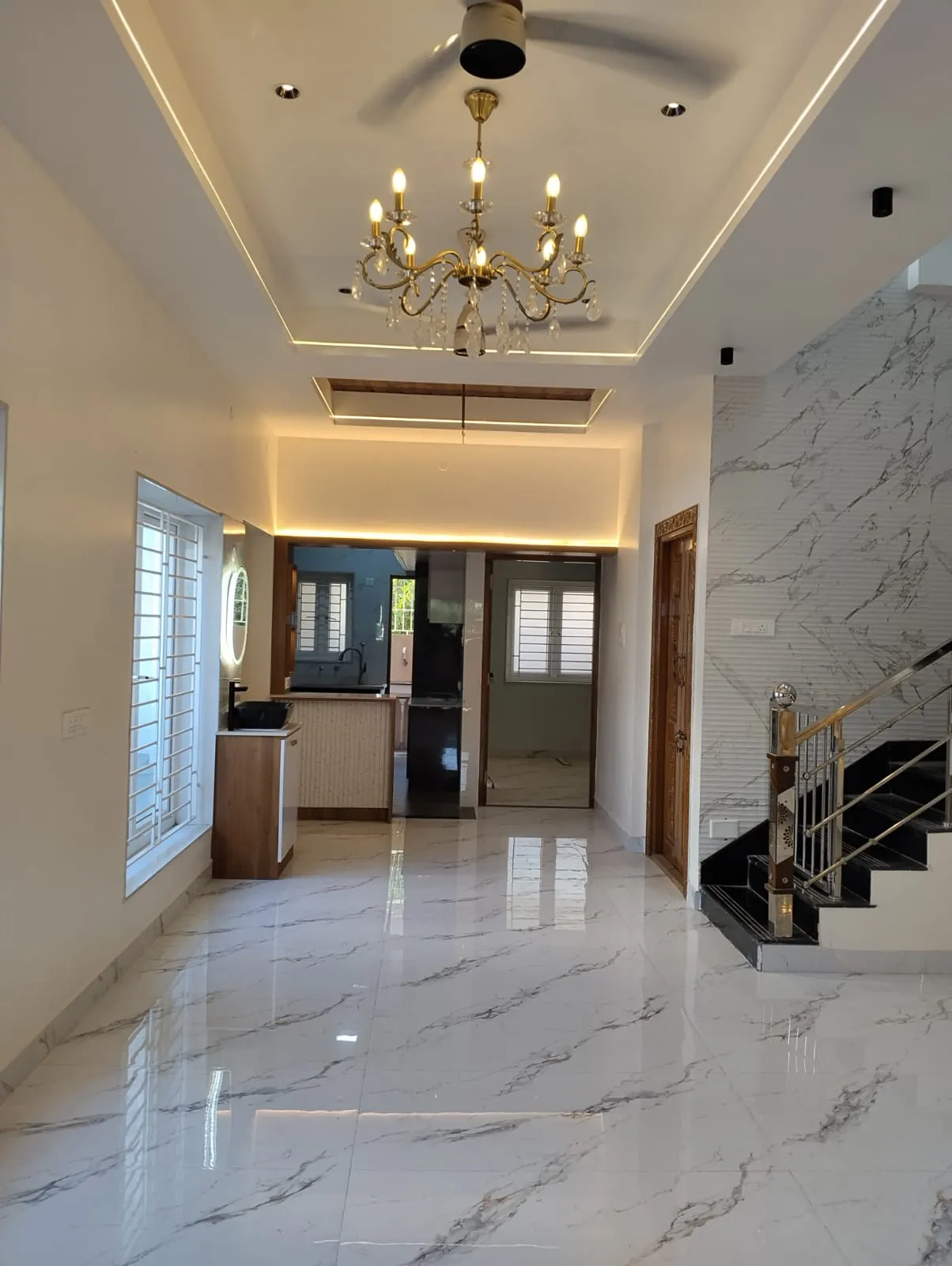 Modern Living Hall with Marble Flooring, Chandelier, and Feature Staircase Wall Display Cabinets Desk and Decor 