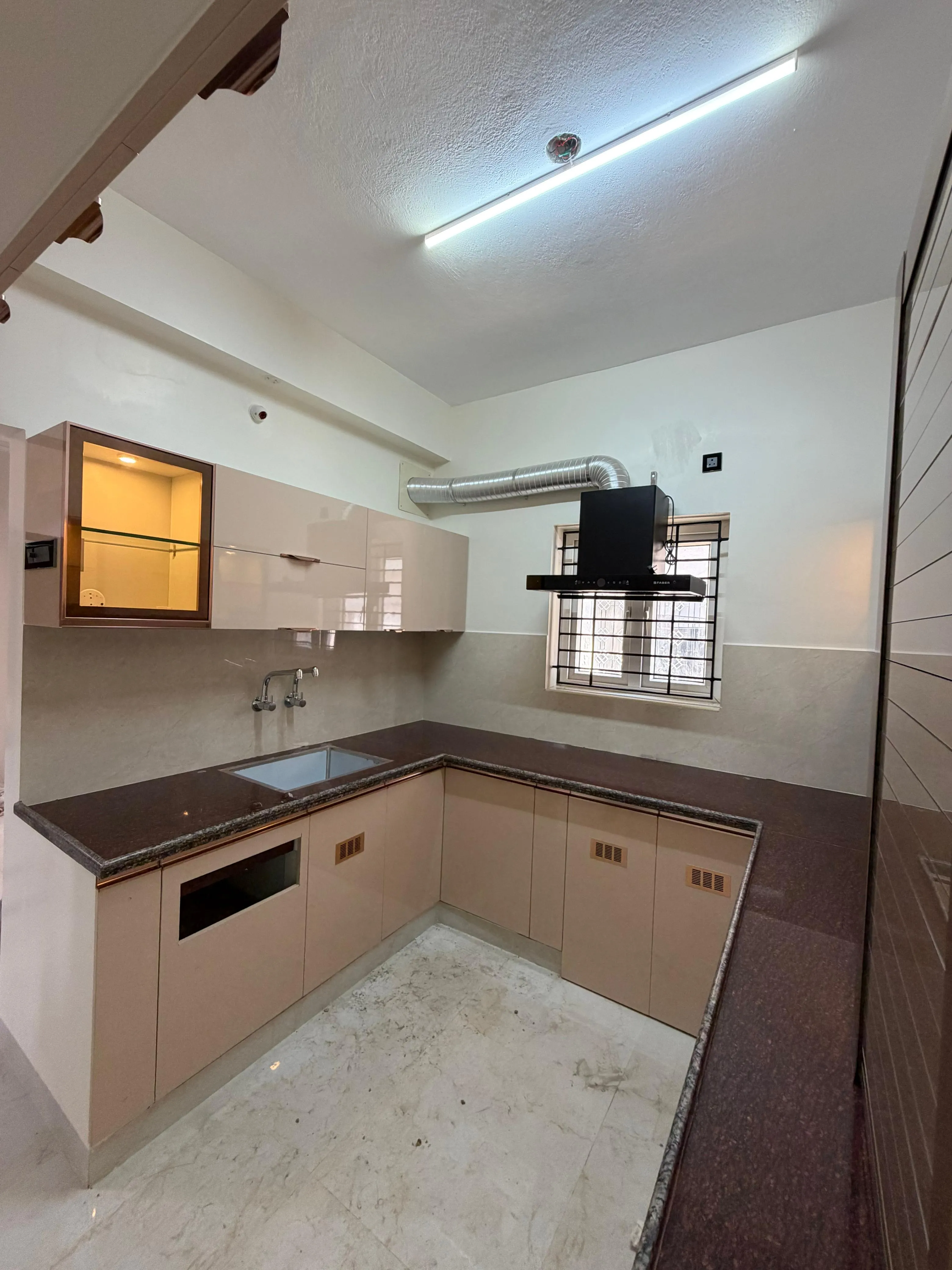 Modular Kitchen with High-Gloss Beige Cabinets and Integrated Chimney with Base Cabinets at Deskanddecor